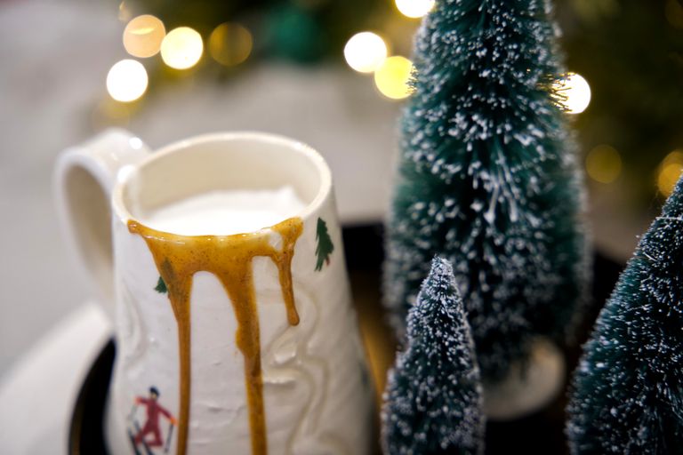 Gingerbread latte with a drip of sauce on the side in a wintery mug